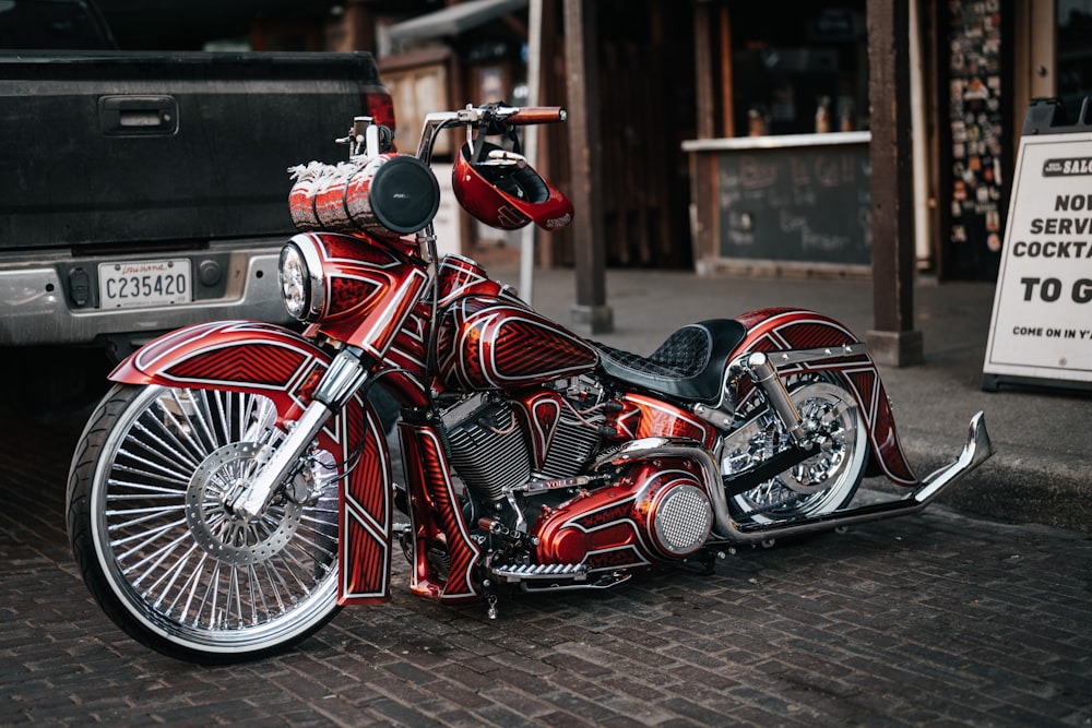 a red motorcycle parked next to a truck