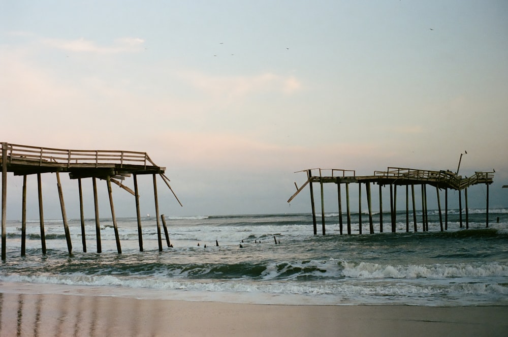 a couple of wooden piers sitting on top of a beach