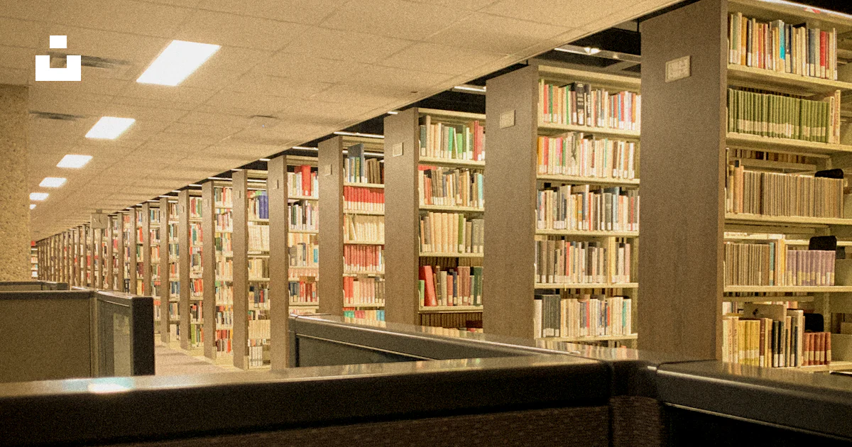 A row of bookshelves in a library filled with lots of books photo ...