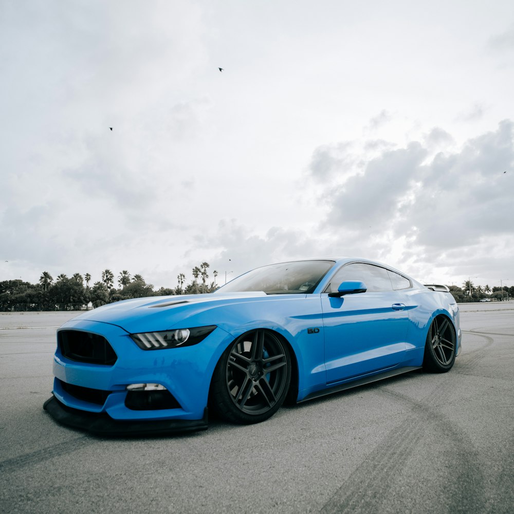 Un Mustang azul estacionado en un estacionamiento