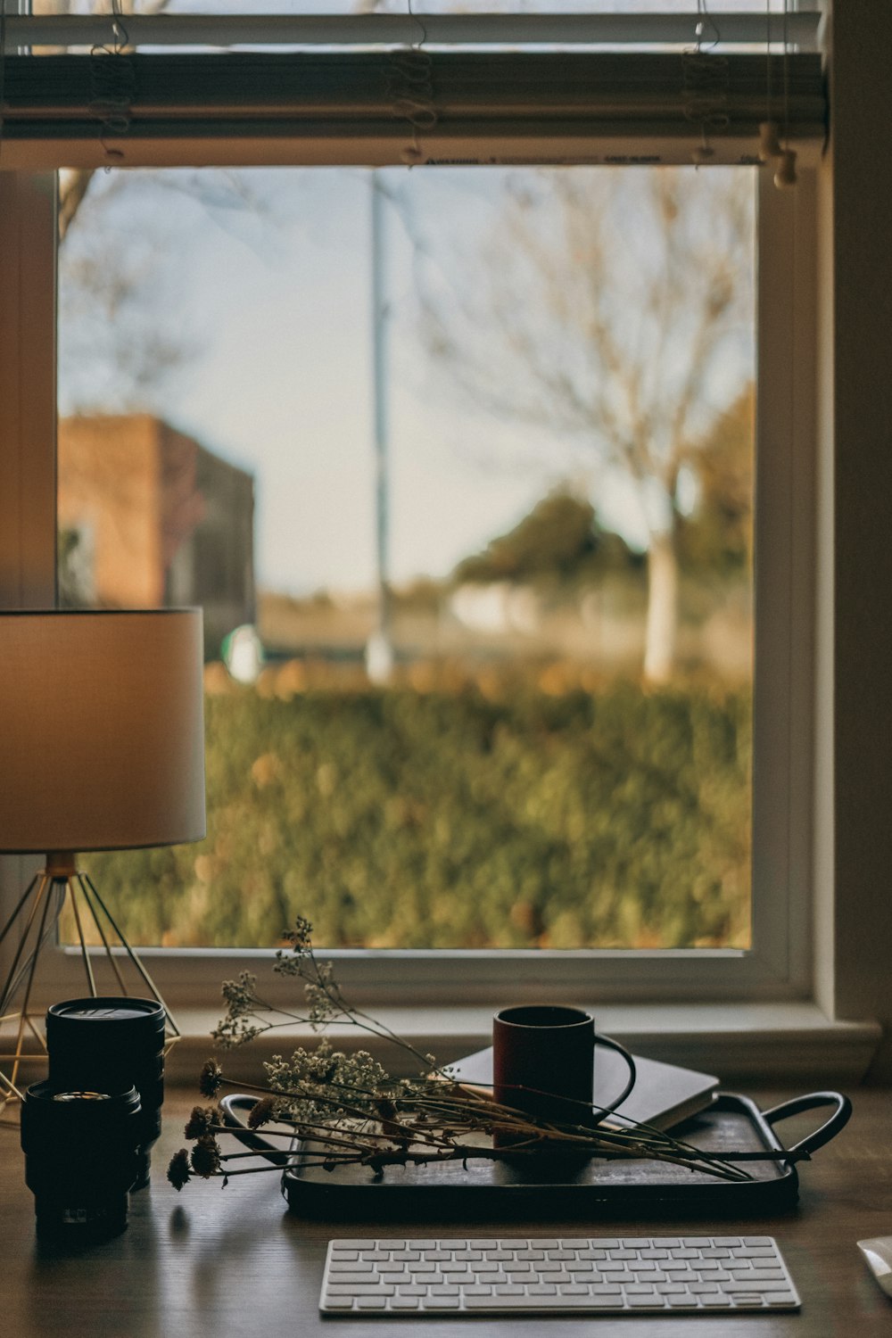 a desk with a keyboard and a lamp