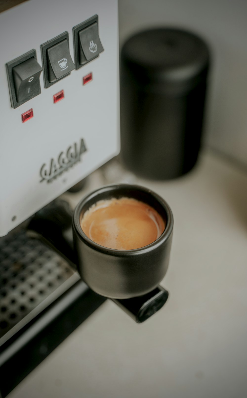 a cup of coffee sitting on top of a coffee maker