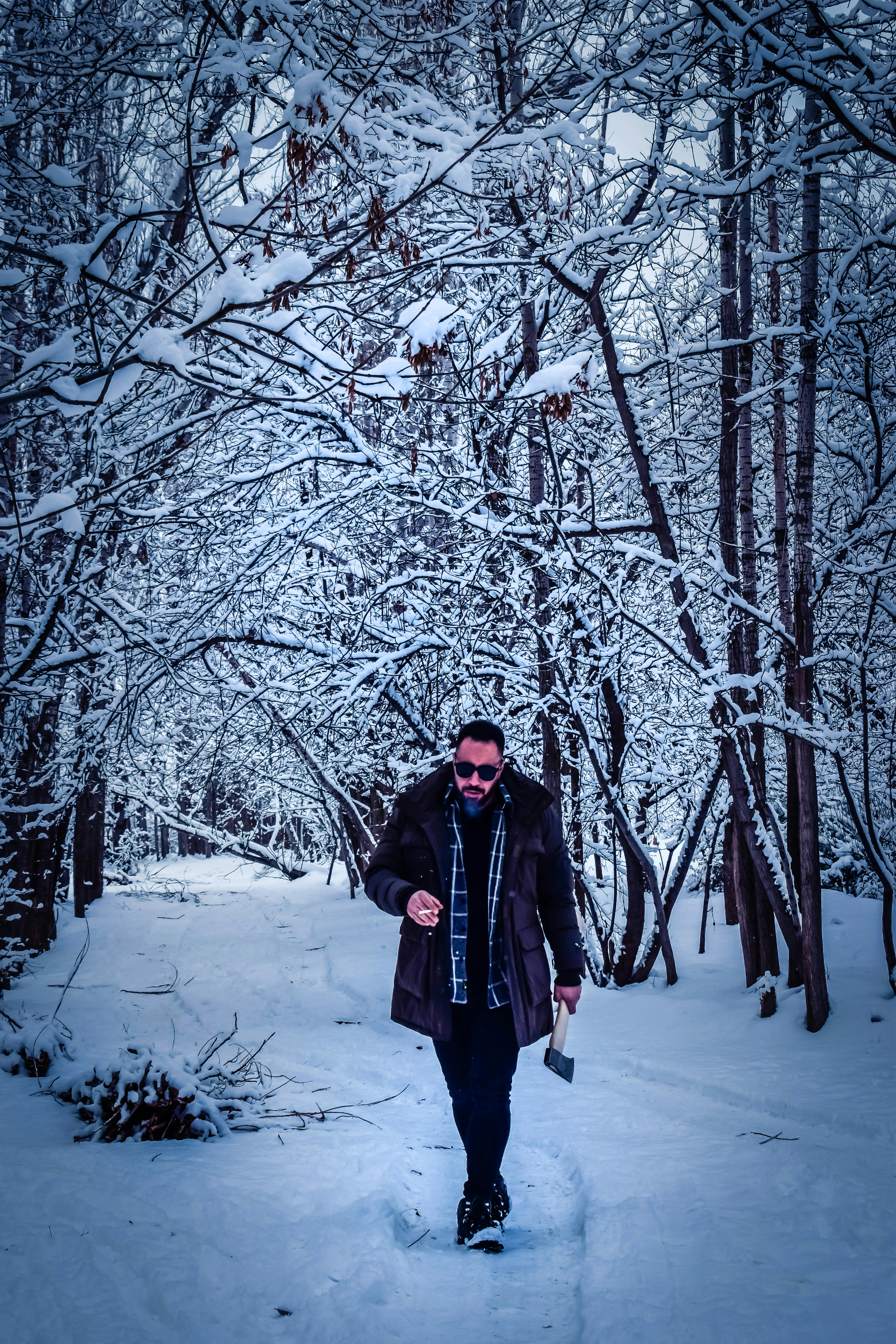Un uomo che cammina attraverso una foresta coperta di neve