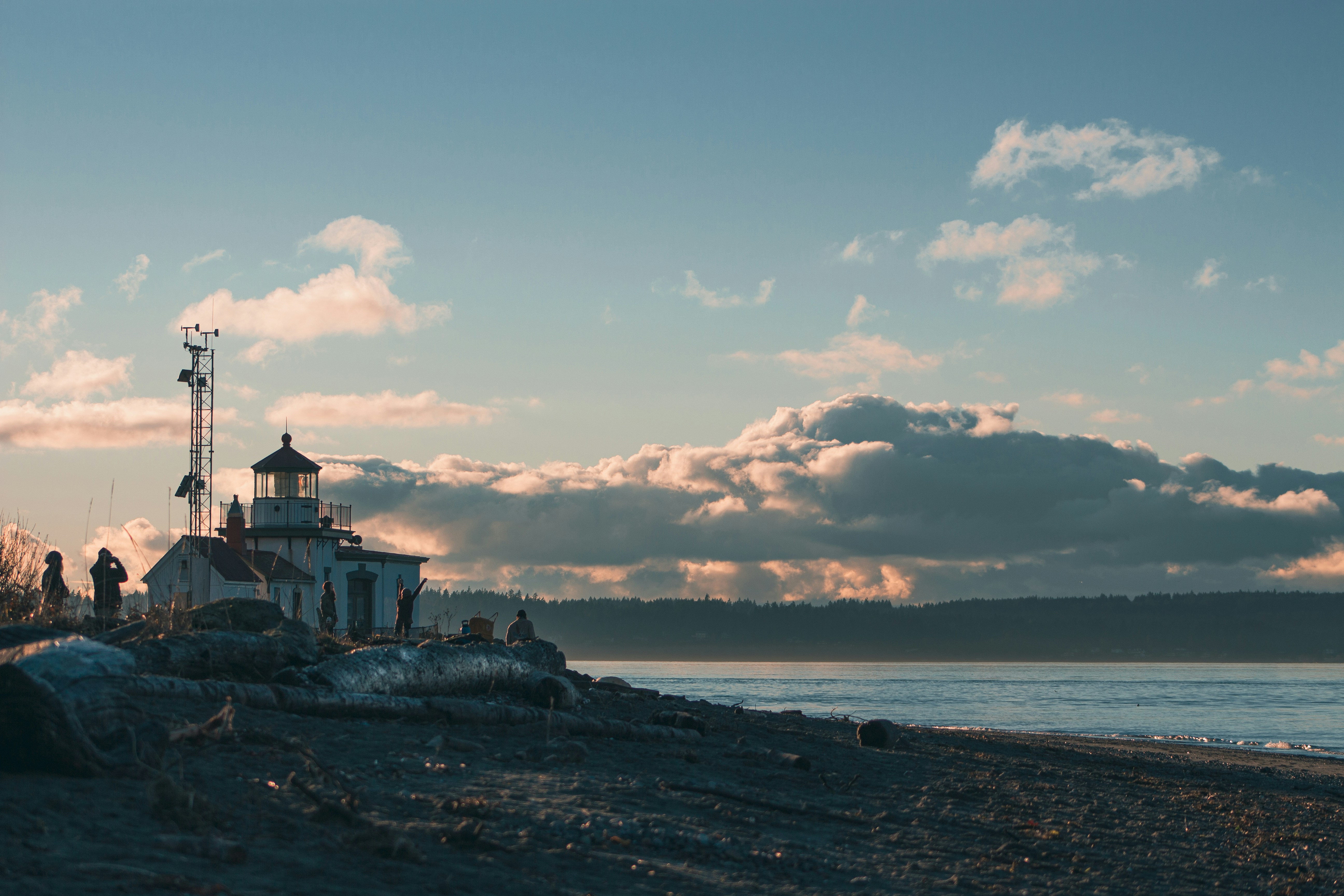 a lighthouse sitting on top of a beach next to the ocean