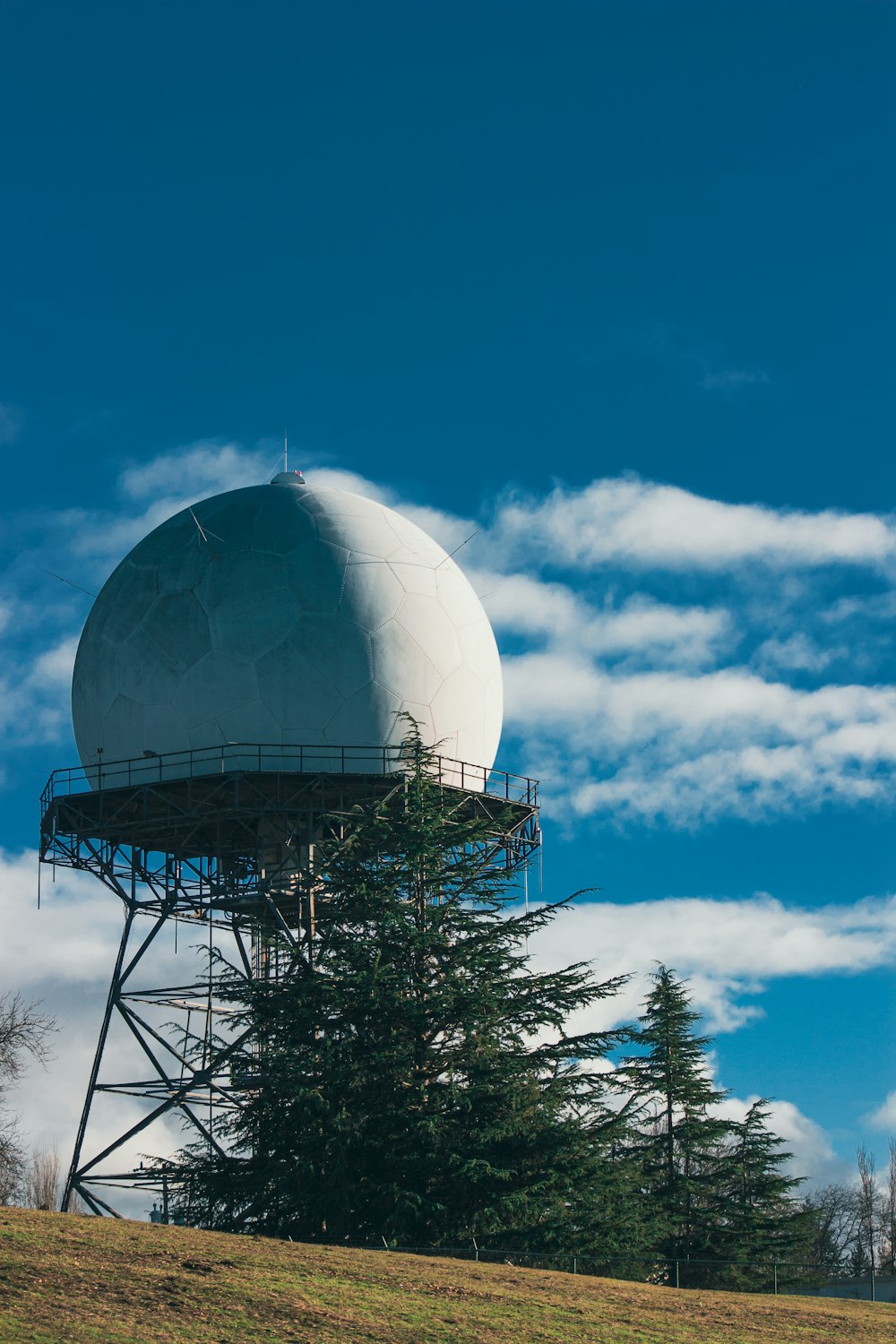 a large white water tower sitting on top of a hill