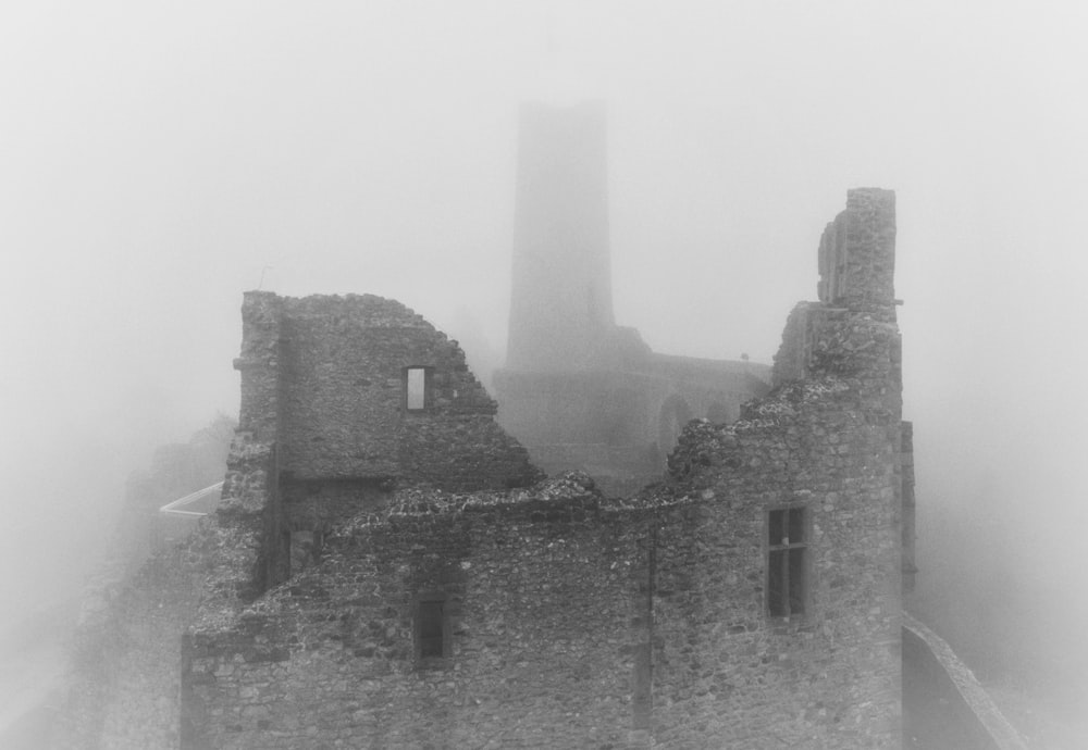 a castle in the fog with a clock tower in the background