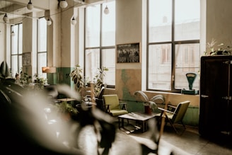Warm, natural-toned room with green and beige accents, showcasing art pieces and a cozy corner for workshops.
