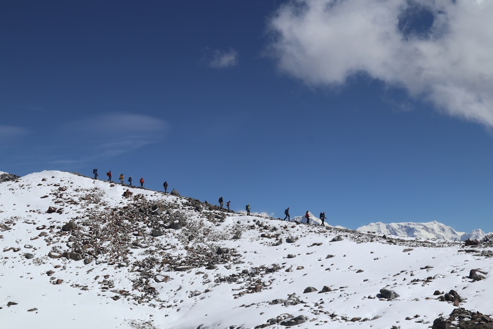 a group of people standing on top of a snow covered mountain