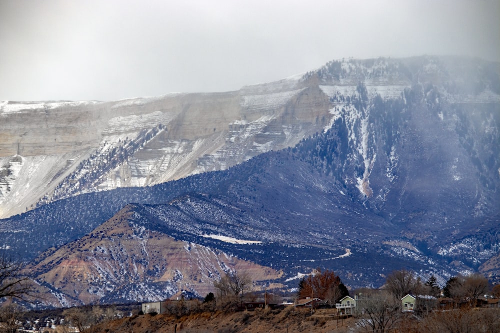 a snow covered mountain with houses in the foreground