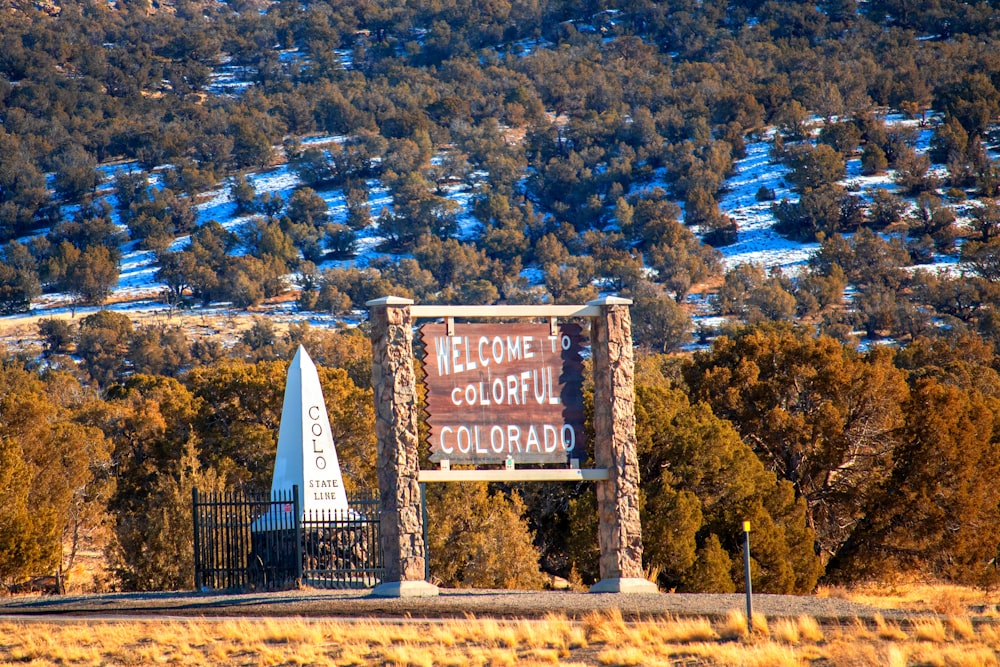 a welcome sign in front of a mountain