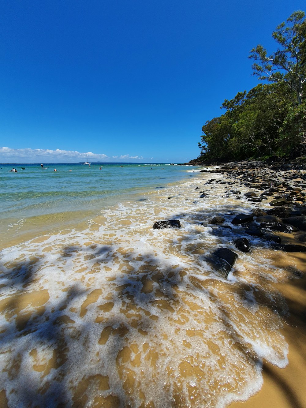 a sandy beach with waves coming in to shore