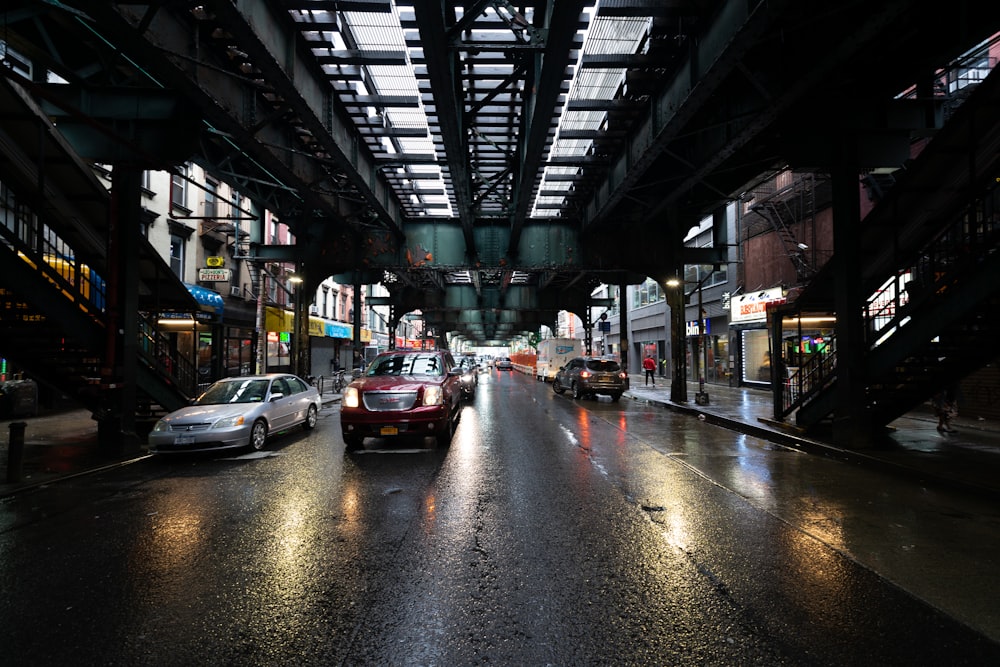 a city street filled with lots of traffic under a bridge