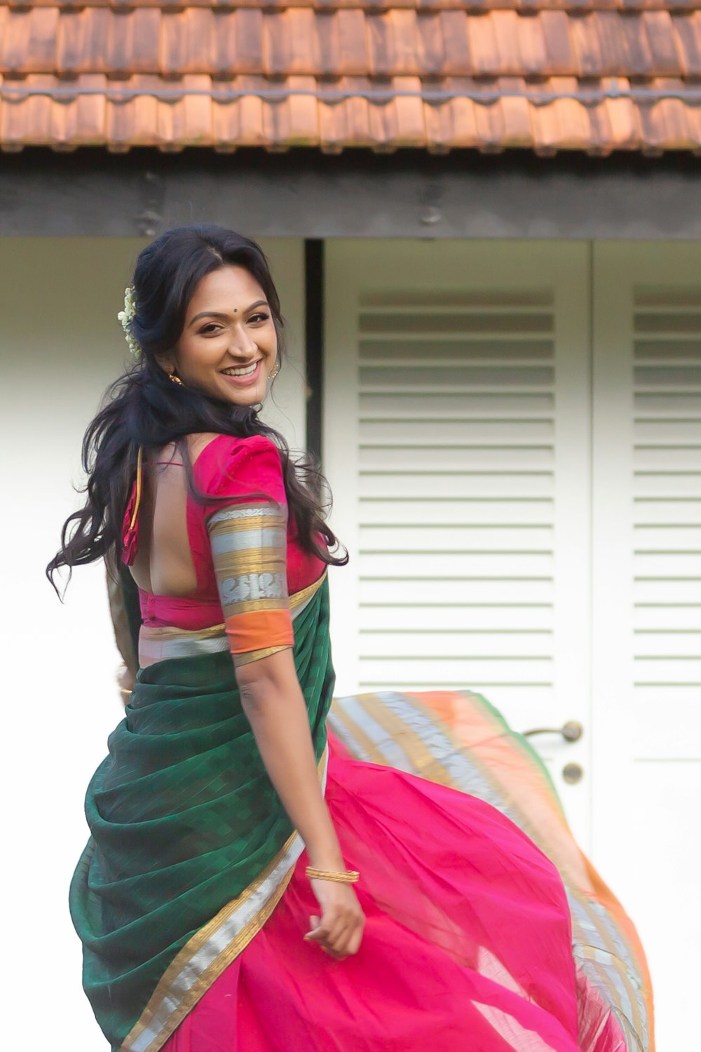 a woman in a pink and green sari