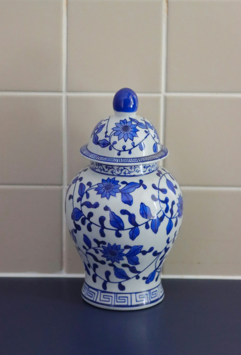 a blue and white vase sitting on top of a counter