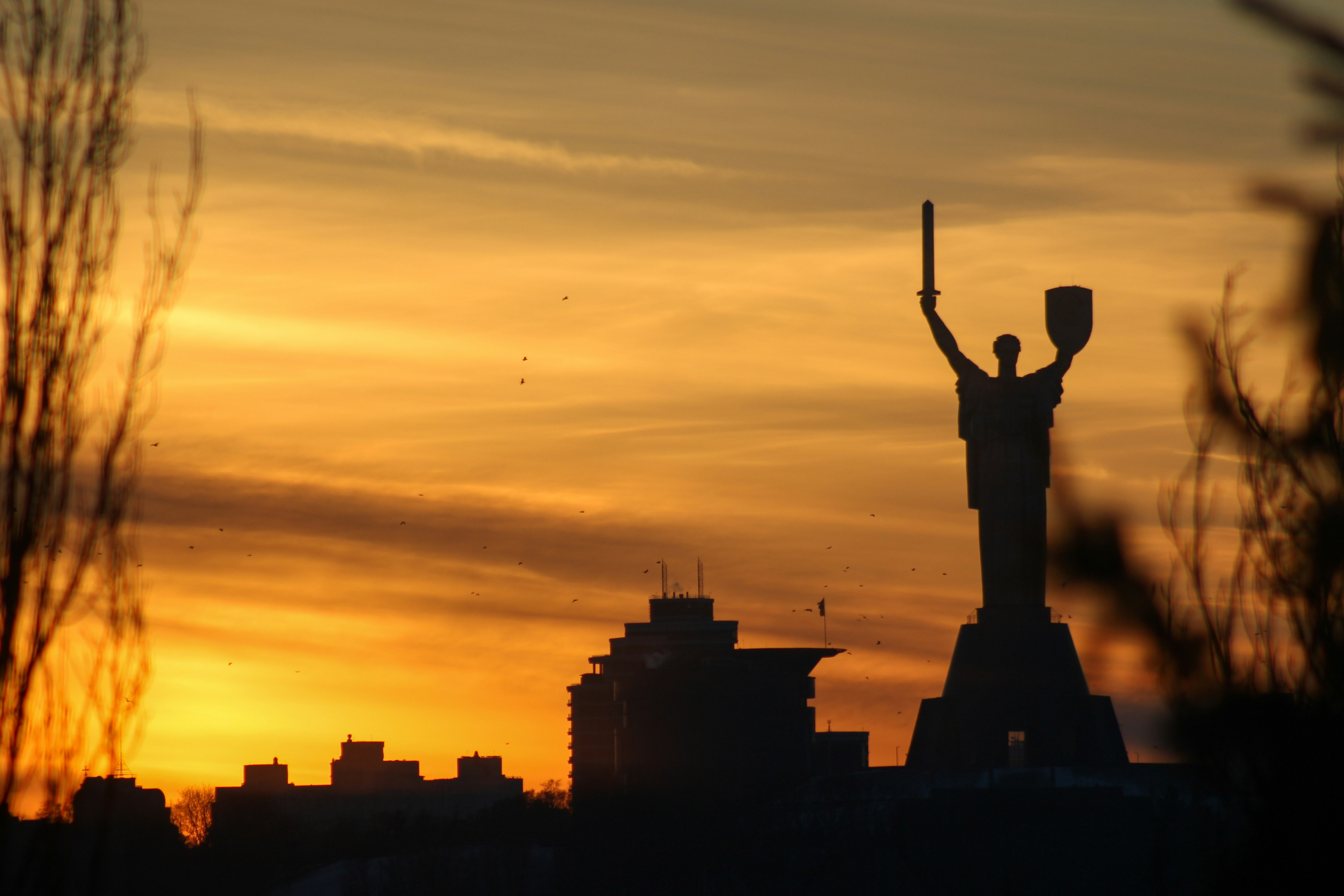 the statue of liberty is silhouetted against a sunset
