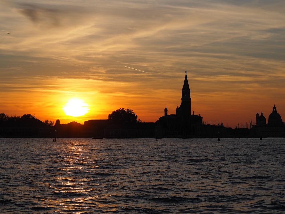 a large body of water with a sunset in the background