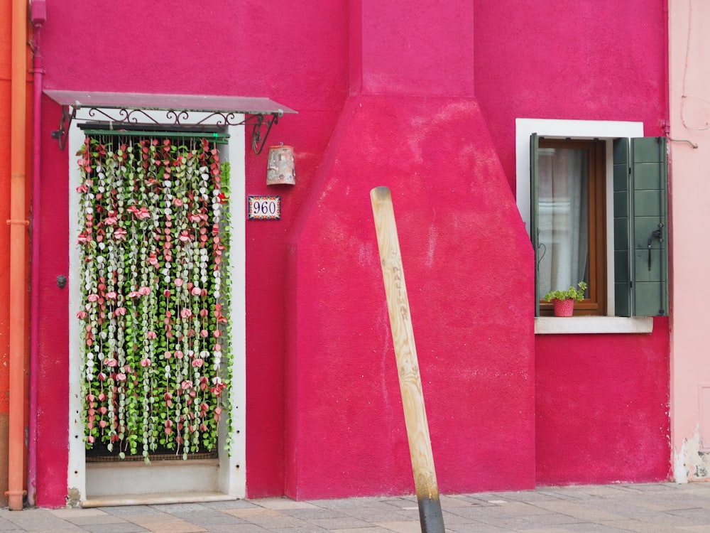 a pink building with a wooden pole in front of it