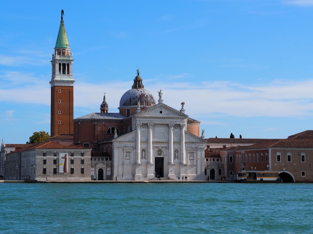 a large building with a clock tower next to a body of water