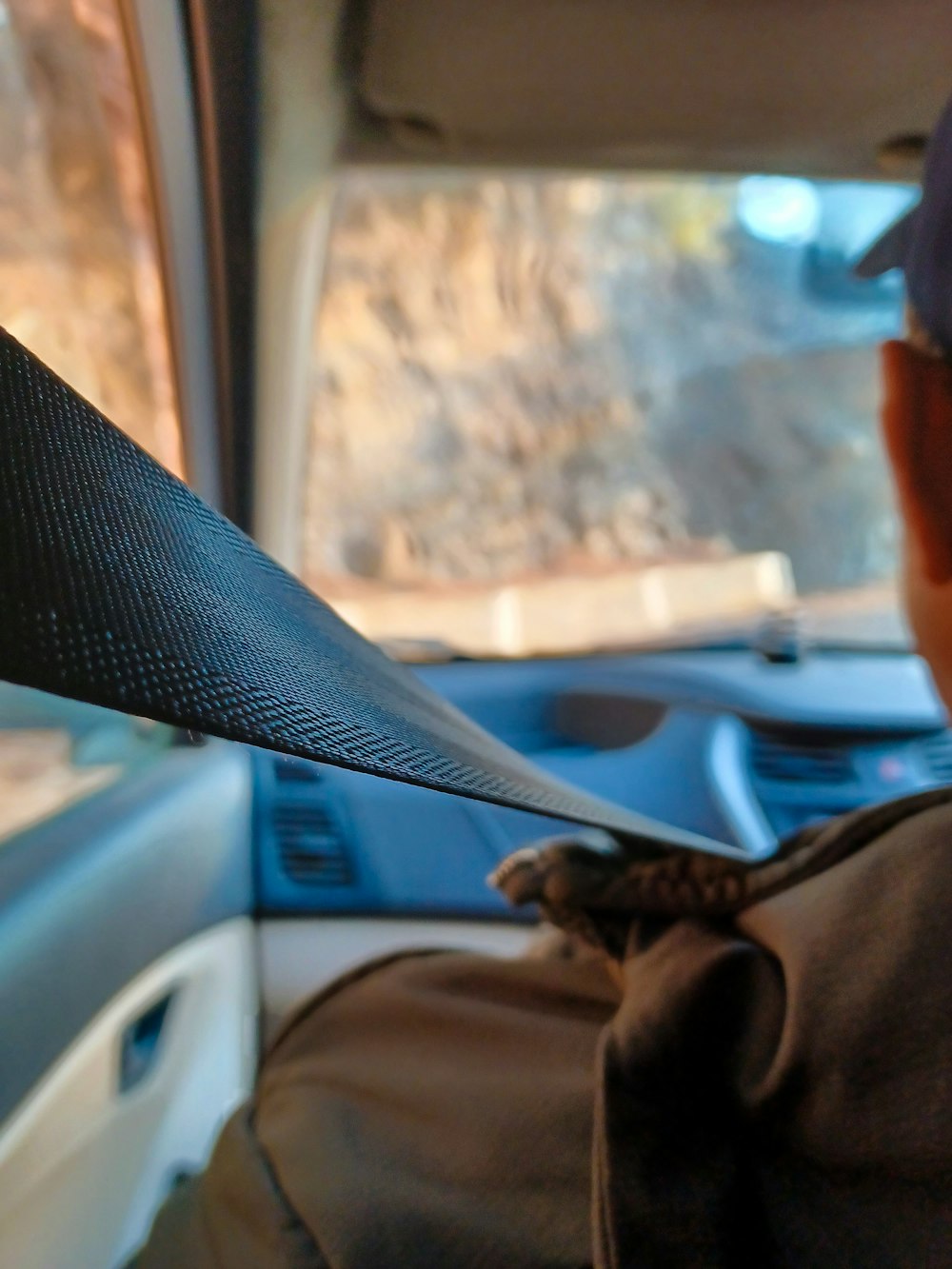 a person cutting a piece of cloth in the back of a car