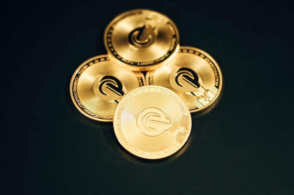 three gold coin sitting on top of a black table