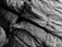 Tightly packed and stacked burlap sacks with visible textures and patterns of the fabric, held together by straps.