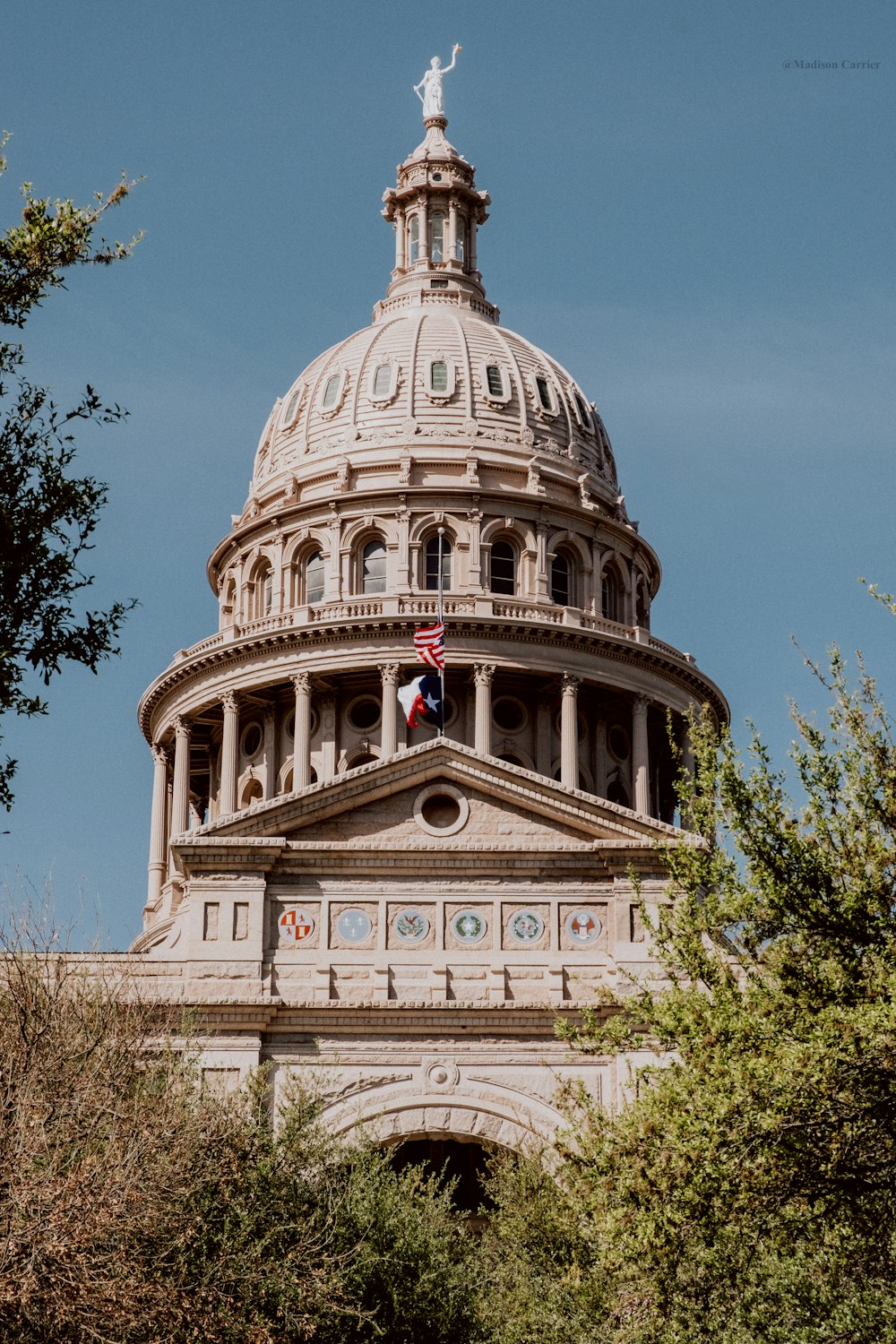 the dome of a building with a flag on top