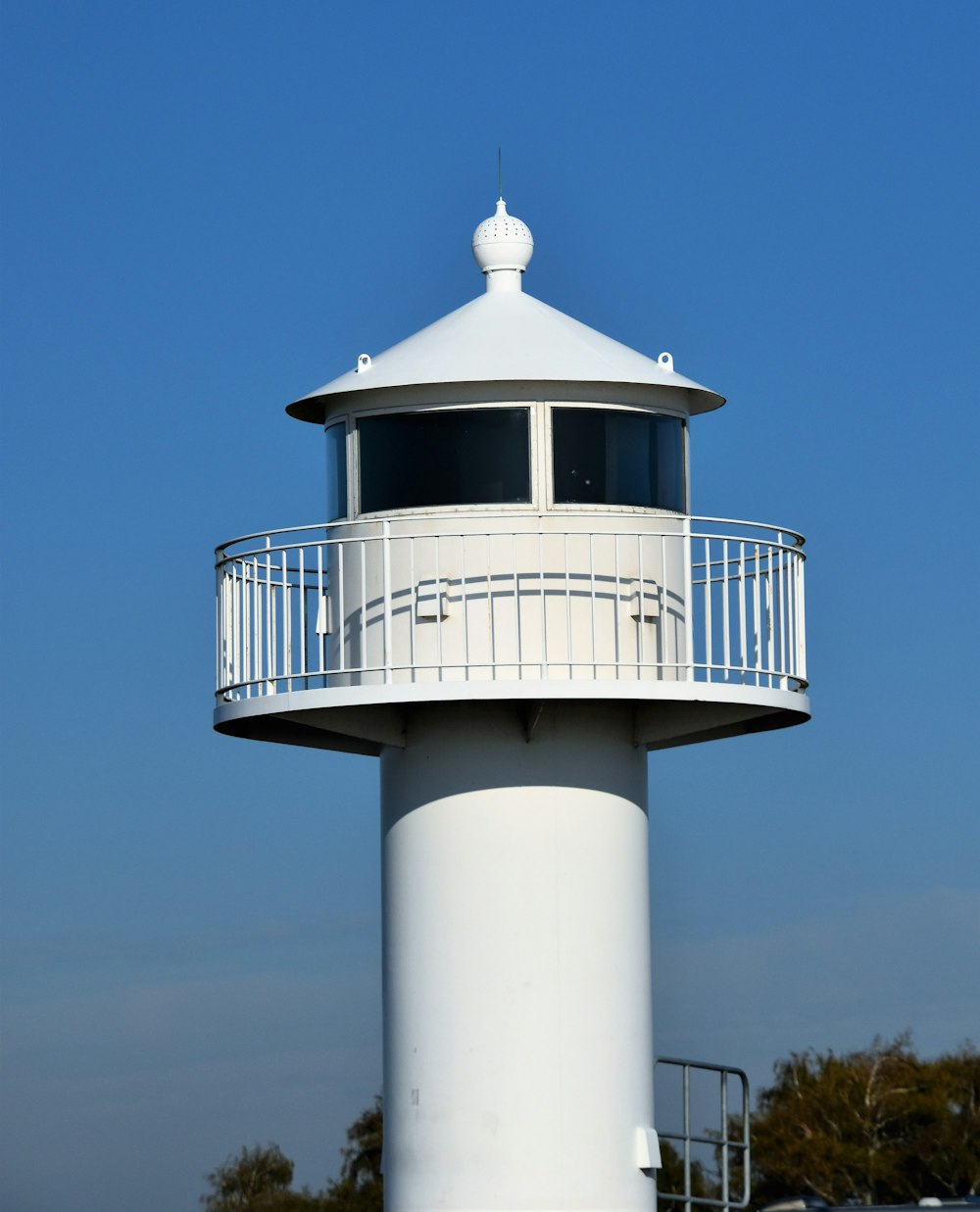 a white lighthouse with a balcony on top of it