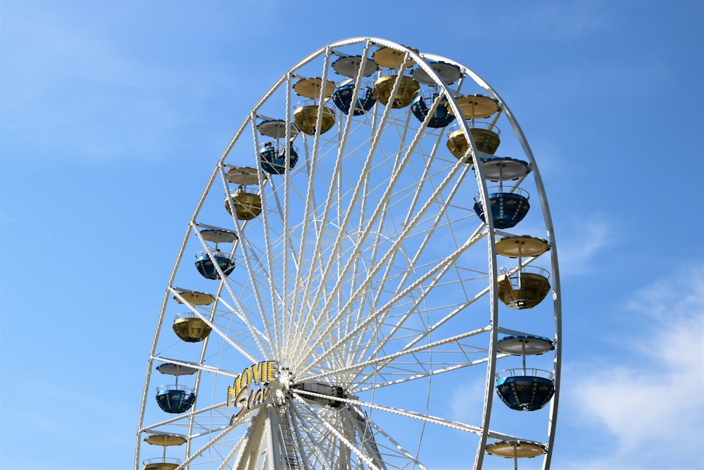 a ferris wheel against a blue sky with clouds