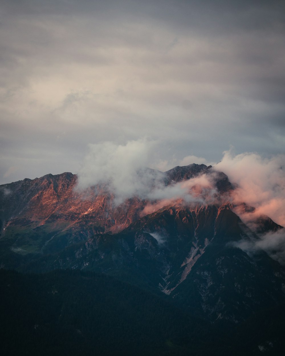 a view of a mountain covered in clouds