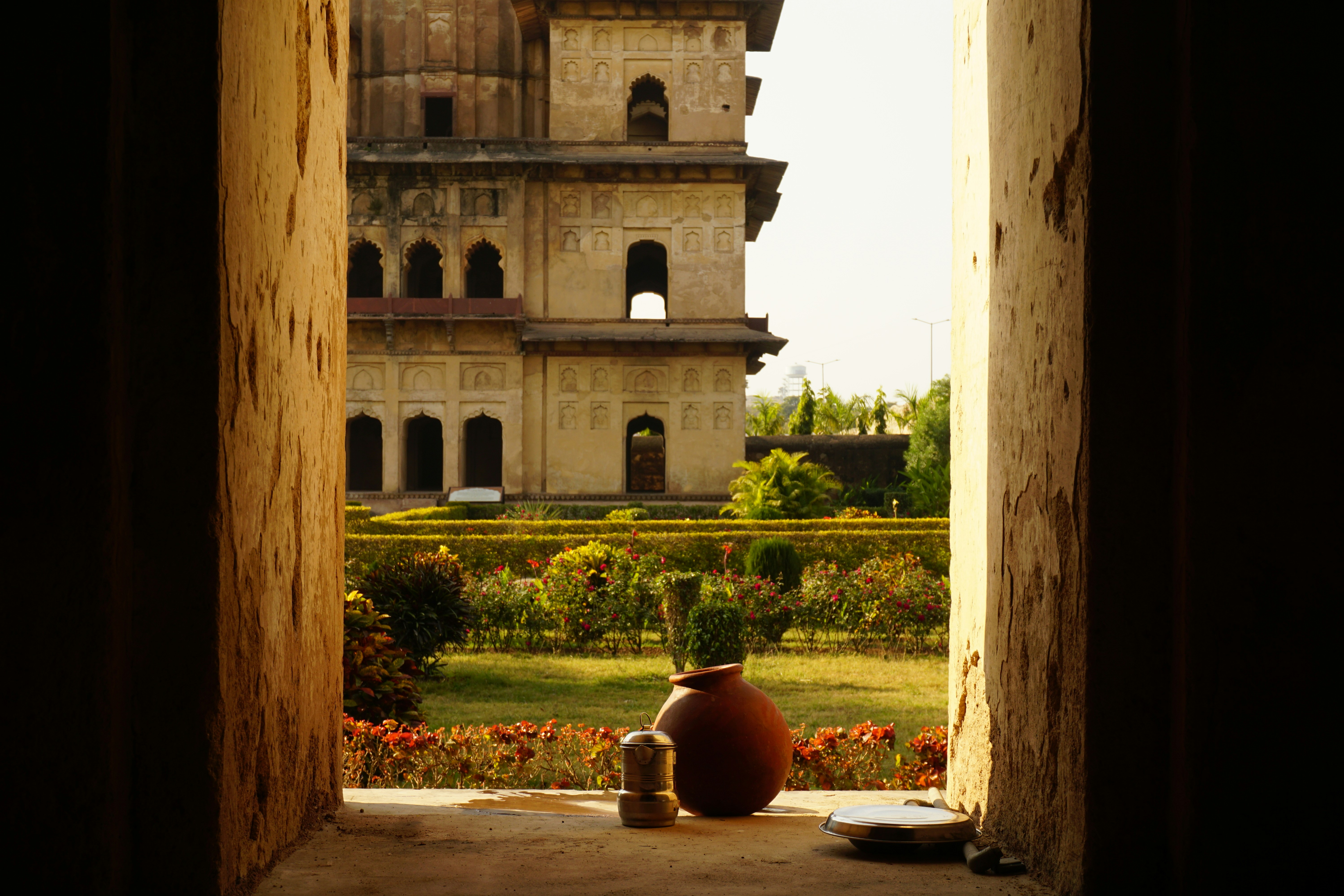 a vase sitting on the ground in front of a building, 