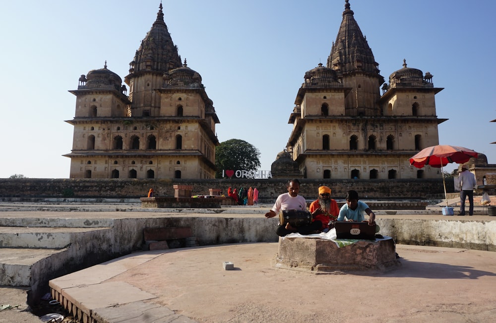 a couple of people sitting on top of a stone bench