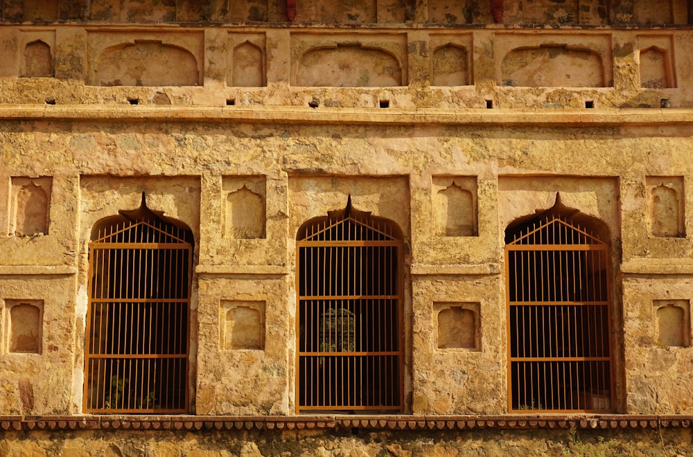 a stone building with four windows and bars