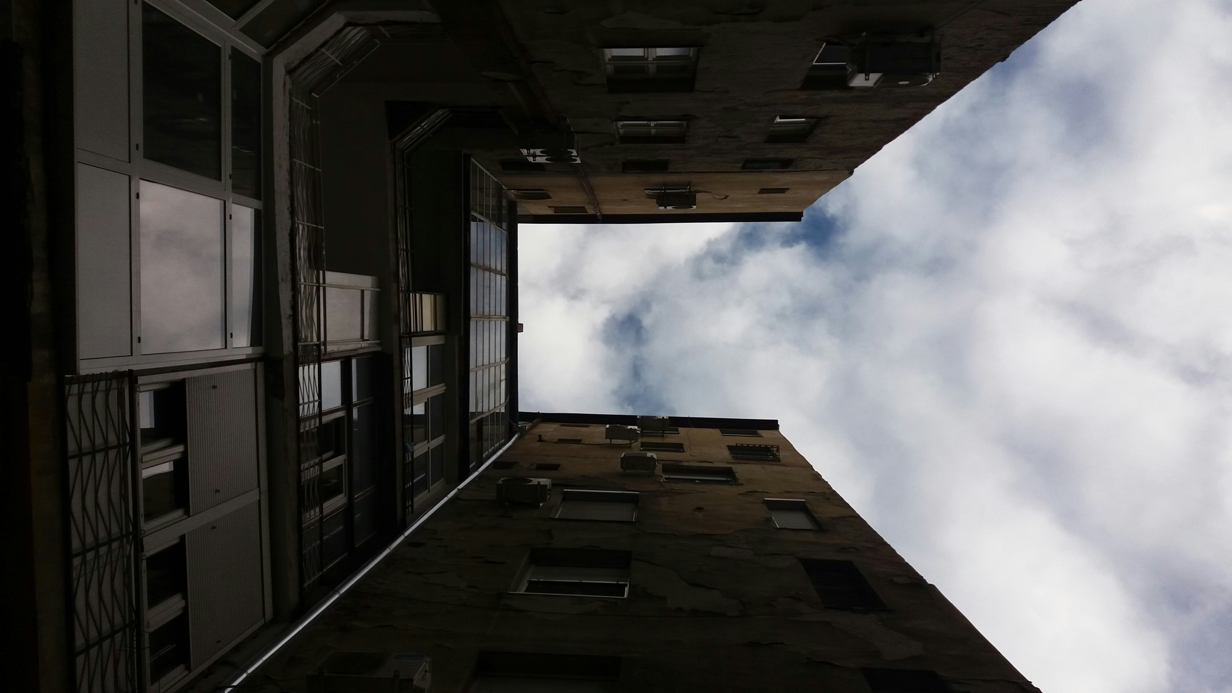 looking up at a tall building with a sky background