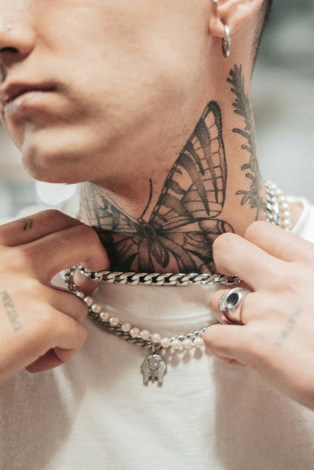 a man with a butterfly tattoo on his neck