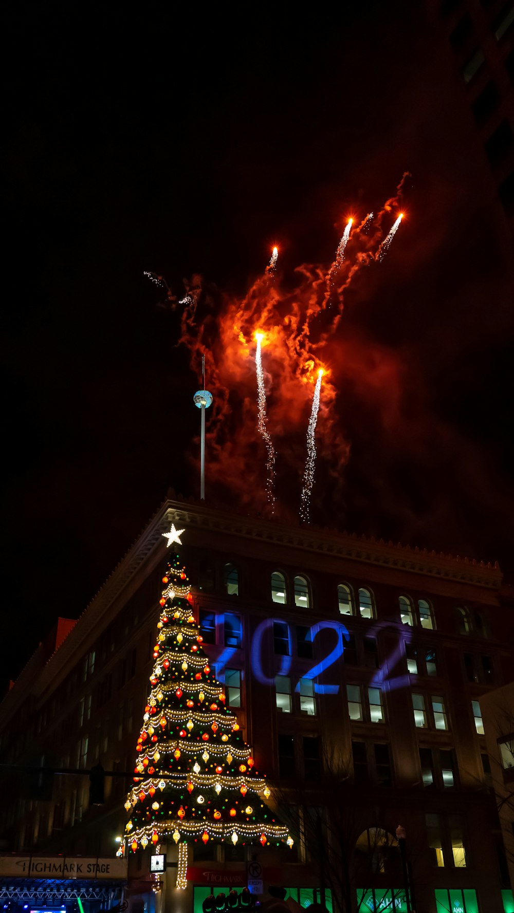 a large christmas tree is lit up in front of a building
