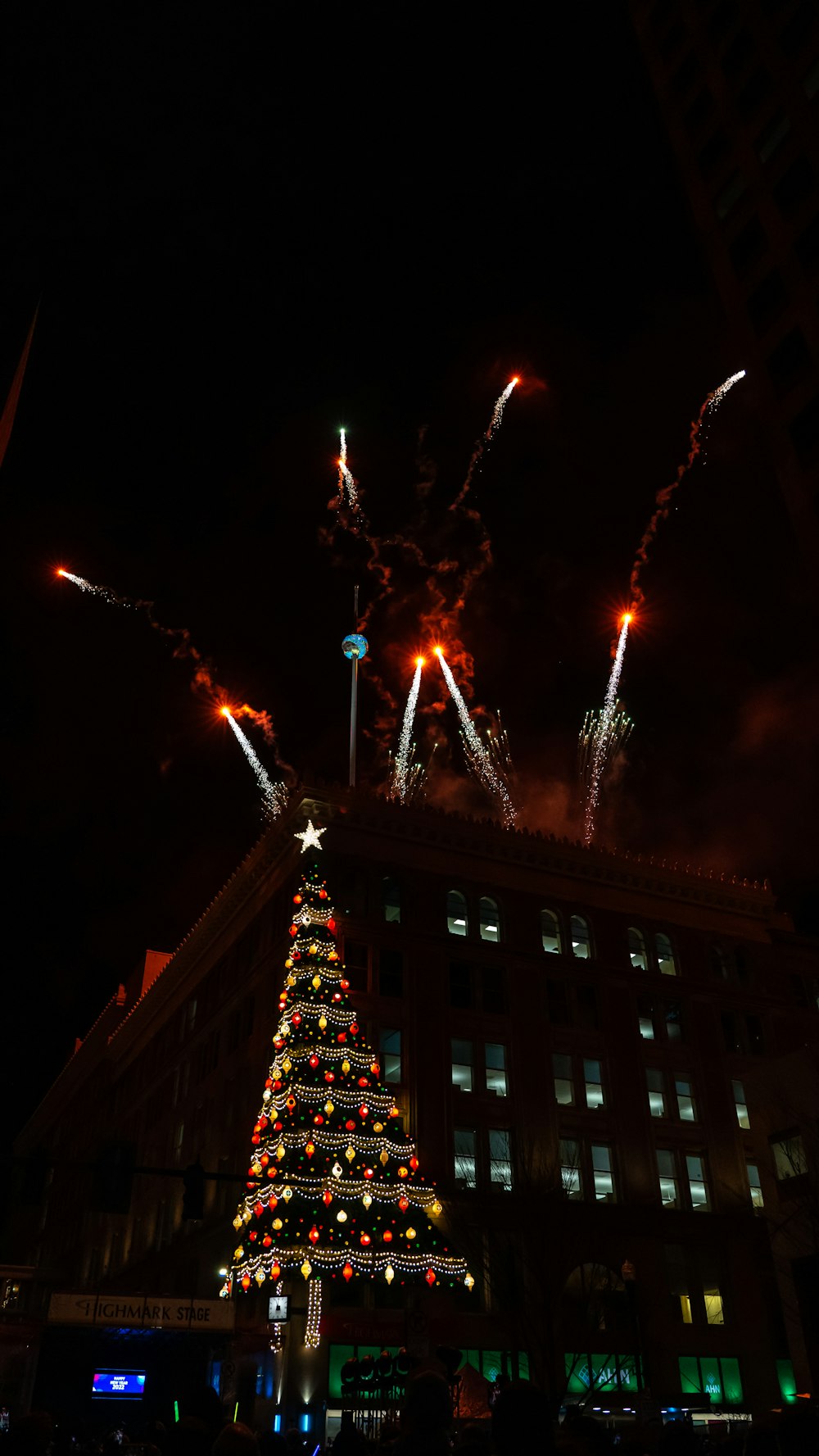 a christmas tree is lit up in front of a building