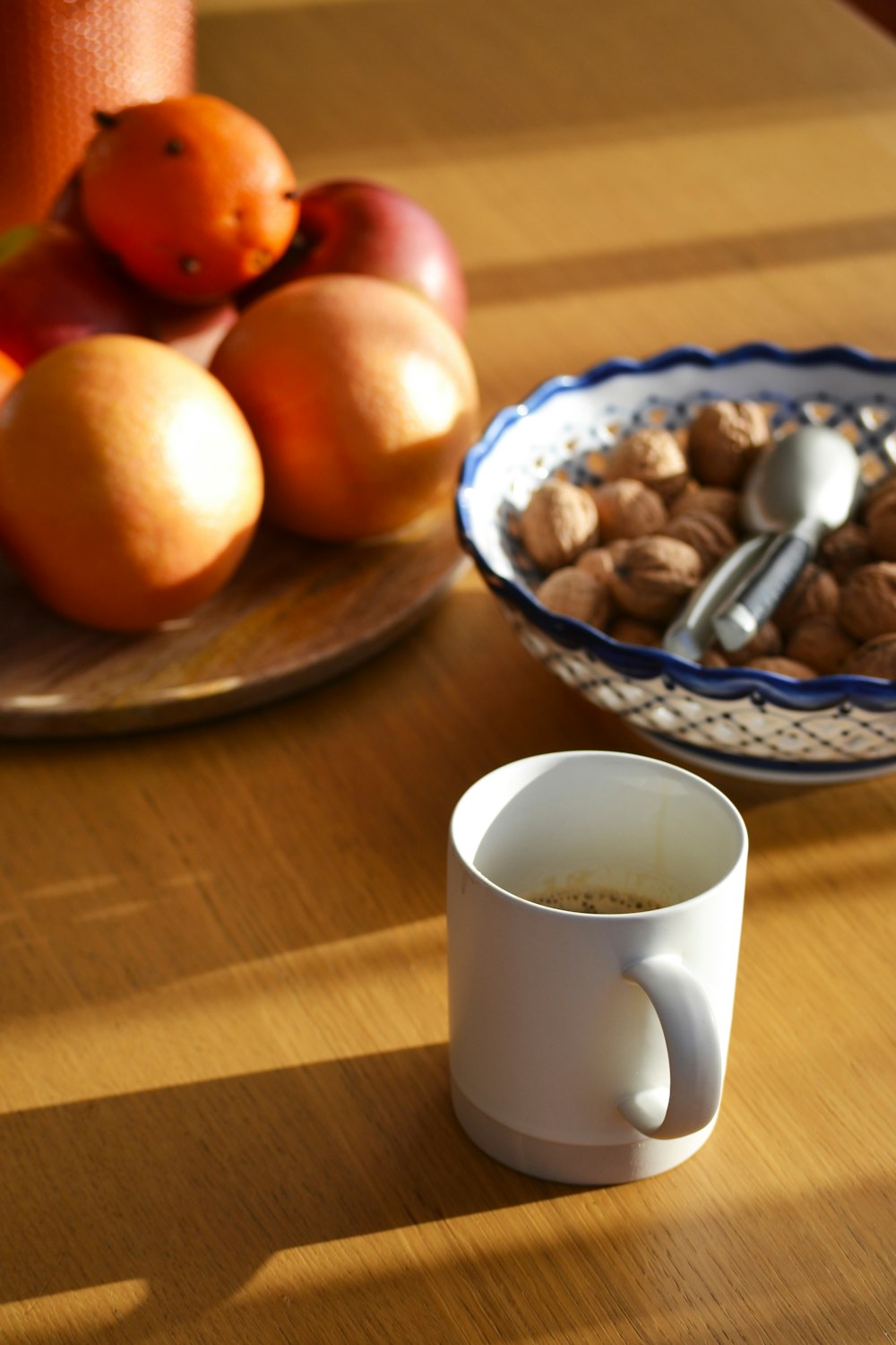 a bowl of fruit and a cup of coffee on a table