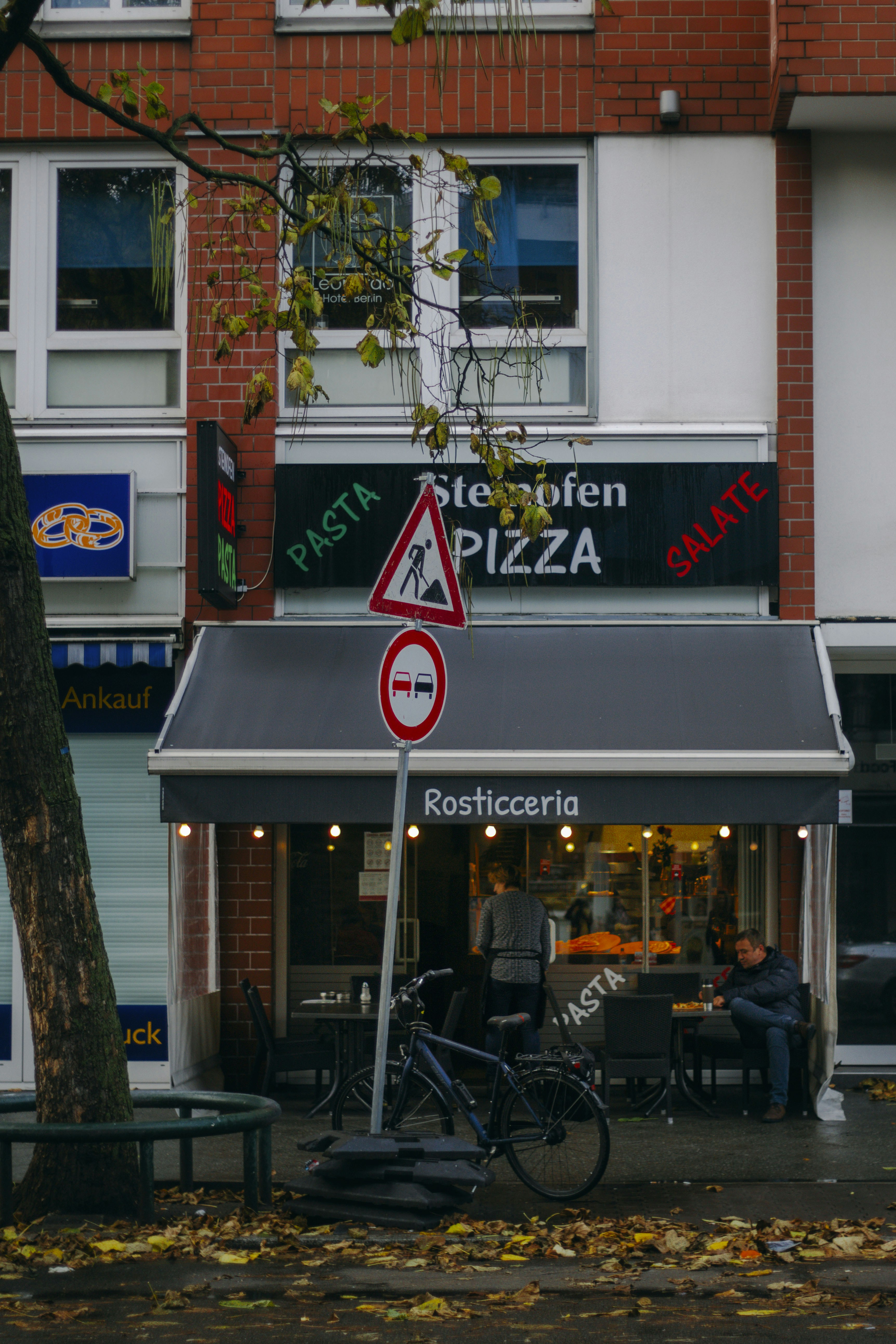 a street sign in front of a pizza shop