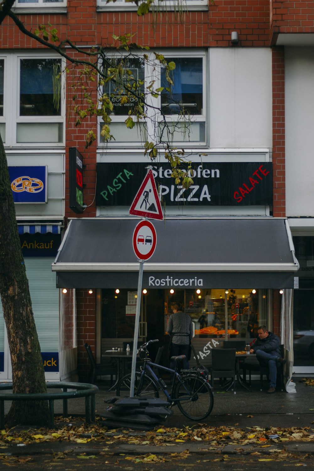 a street sign in front of a pizza shop