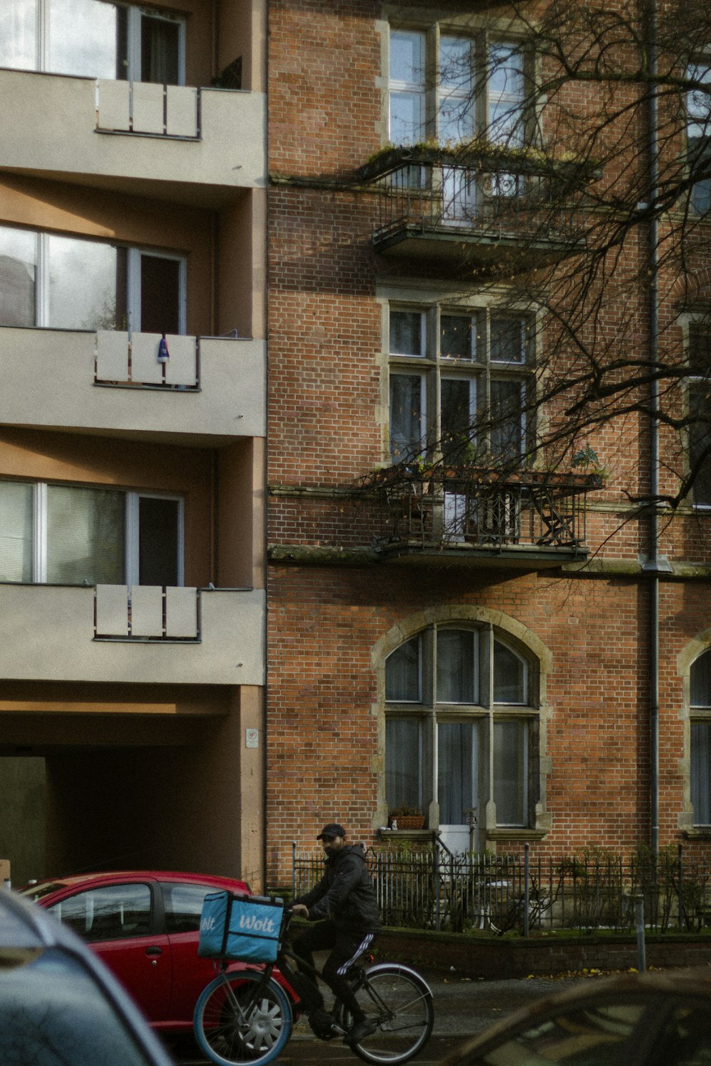 a man riding a bike down a street next to a tall building