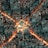 A complex 3D rendering resembling an abstract cityscape with intricate geometric patterns. The scene is illuminated by glowing orange lines that create a striking contrast with the dark teal structures. The patterns form a grid-like arrangement, suggesting a futuristic or cybernetic environment.