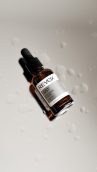 a close up of a dropper bottle with drops of water on it