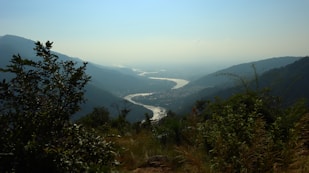 a river flowing through a valley surrounded by mountains