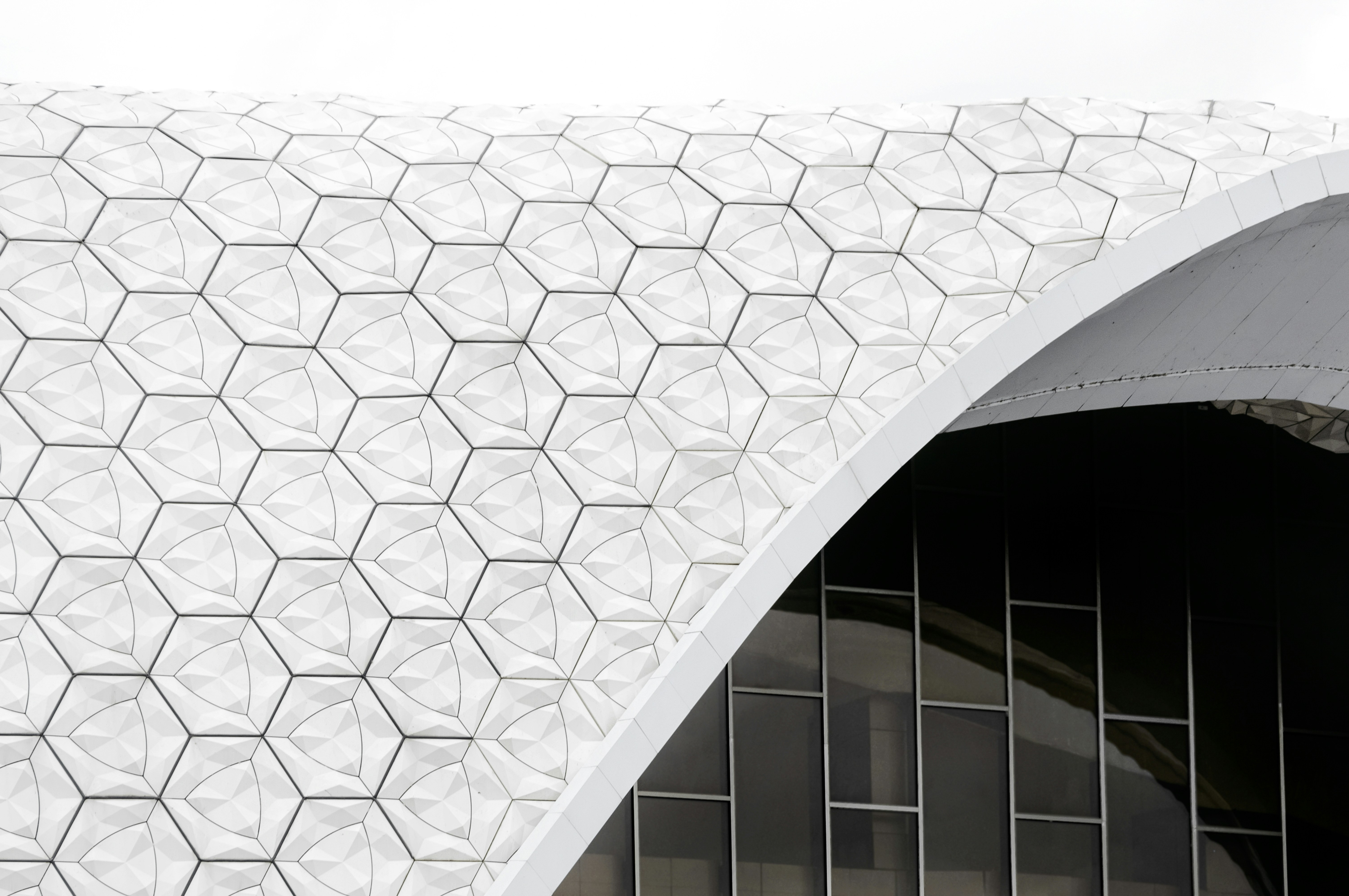 a large white building with a curved roofby Nima Mot