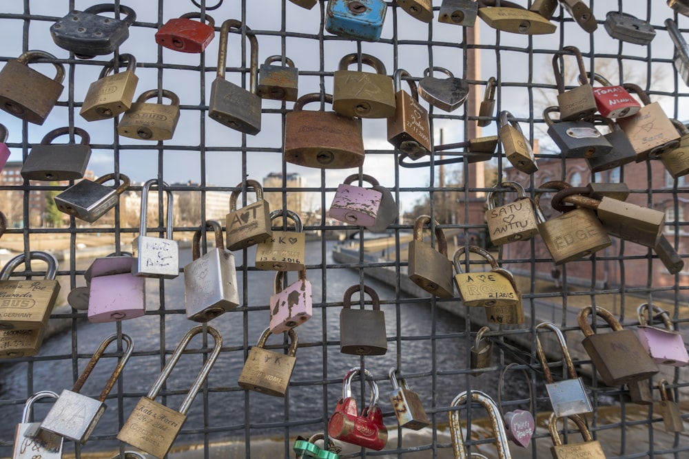 a bunch of padlocks attached to a fence