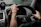 Close-up of a driver’s hand on the wheel with the Velocis app open on a phone screen