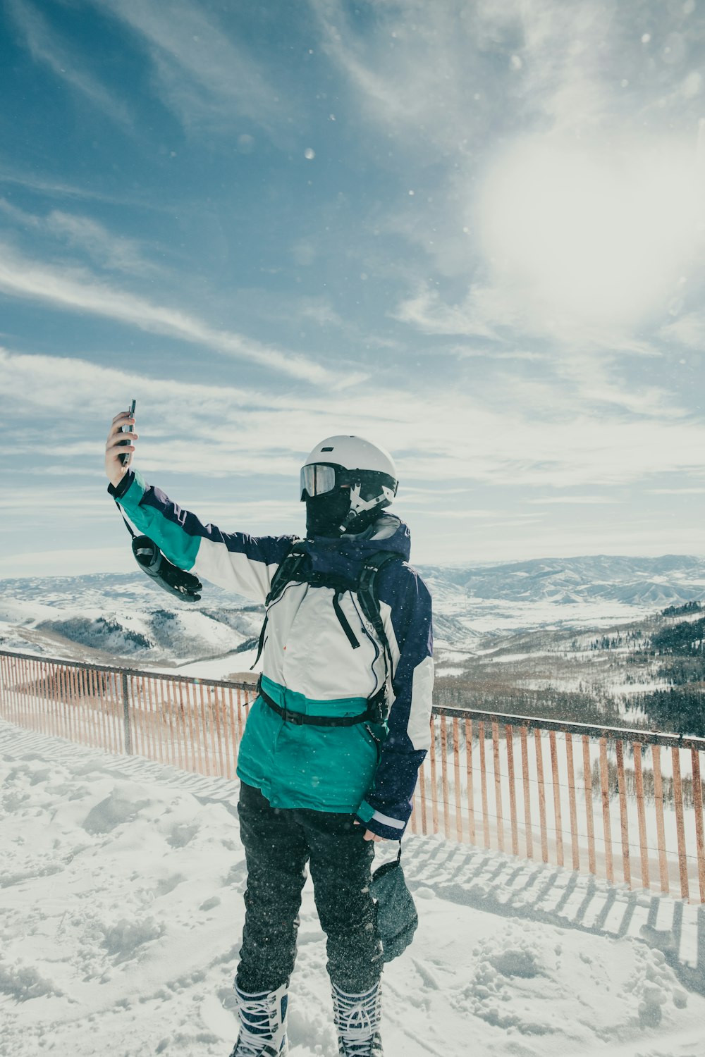 a person standing in the snow holding a snowboard