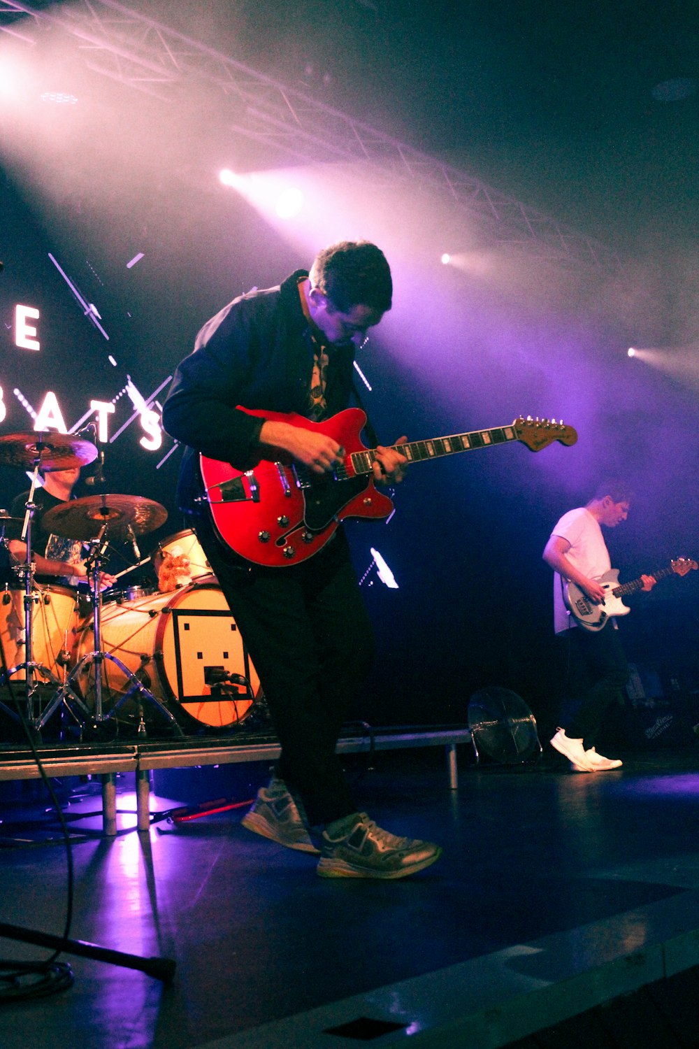 a man standing on a stage playing a guitar