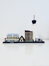 A miniature model of Las Vegas' skyline is displayed, featuring iconic structures such as a blue and white building, a small pyramid with a sphinx, a brown tower, and a tall tower with a red tip.