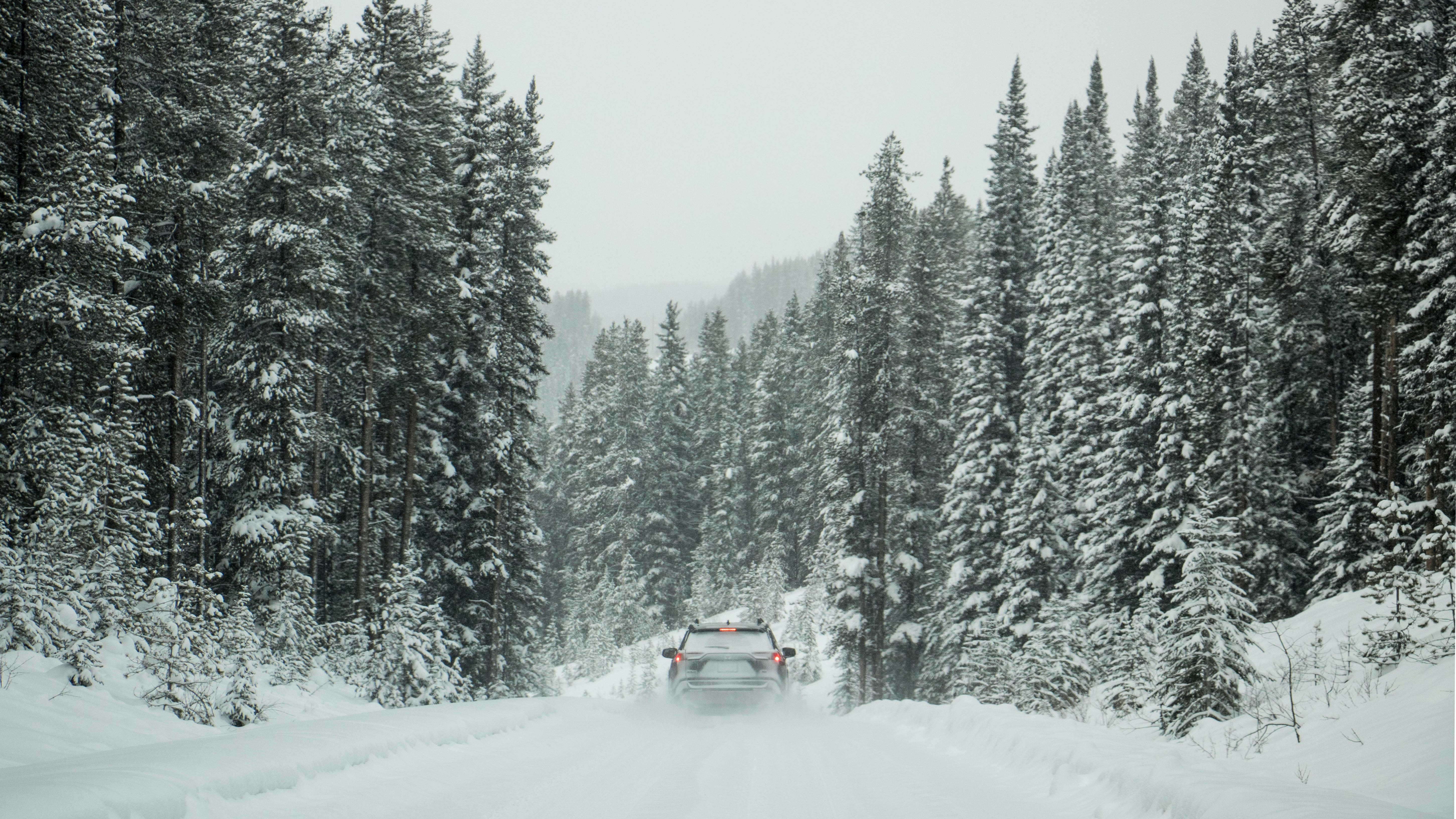 a car driving down a snow covered road